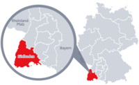 Diese Grafik zeigt eine Karte von Deutschland mit einer detaillierten Ansicht der Region Südbaden. Südbaden ist in Rot hervorgehoben und liegt im südlichen Teil Deutschlands. Ein Lupensymbol vergrößert diesen Bereich, um die Lage genauer darzustellen. 