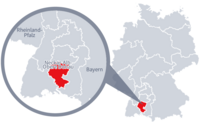 Diese Grafik zeigt eine Karte von Deutschland mit einer detaillierten Ansicht der Region Neckar-Alb-Obere-Donau. Neckar-Alb-Obere-Donau ist in Rot hervorgehoben und liegt im südlichen Teil Deutschlands. Ein Lupensymbol vergrößert diesen Bereich, um die Lage genauer darzustellen. 