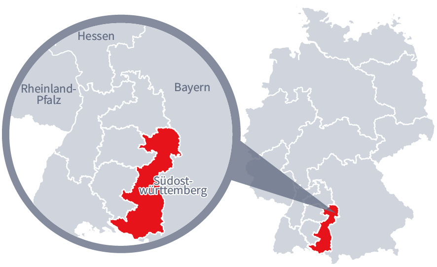 Diese Grafik zeigt eine Karte von Deutschland mit einer detaillierten Ansicht der Region Südostwürttemberg. Südostwürttemberg ist in Rot hervorgehoben und liegt im südlichen Teil Deutschlands. Ein Lupensymbol vergrößert diesen Bereich, um die Lage genauer darzustellen. 